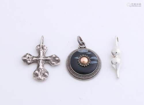 Three silver pendants, one in the form of a rough-edged