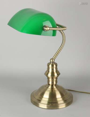 Old desk lamp with green glass shade and brass base.