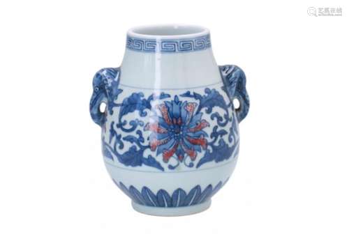 A blue and underglaze red porcelain vase, decorated with flowers. The handles in the shape of