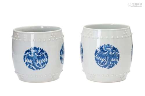 A pair of blue and white round porcelain cachepots, decorated with phoenix and knobs in relief.