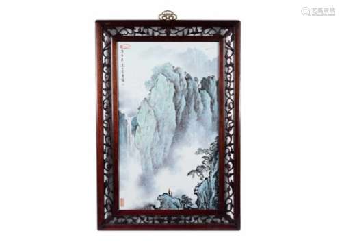 A polychrome porcelain plaque in wooden frame, decorated with a mountainous landscape with a