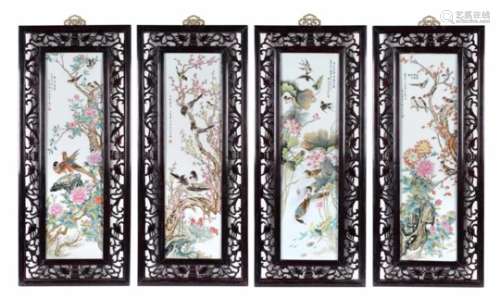 A set of four polychrome porcelain plaques in wooden frames, decorated with a poem, birds and