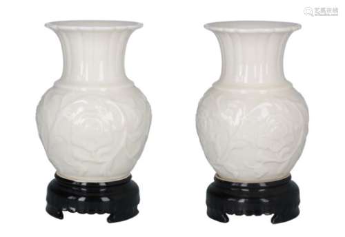 A pair of cream glazed porcelain vases with handles in the shape of a dragon. The bottom black