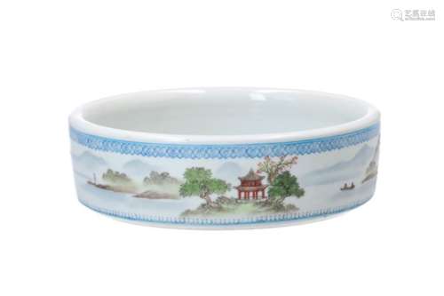 A polychrome porcelain bowl, decorated with a mountainous river landscape with boats and characters.