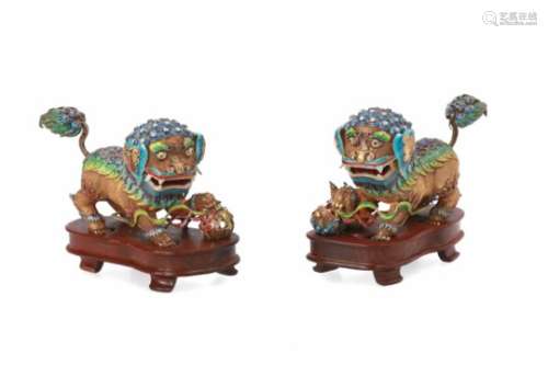 A pair of silver gilded and enameled sculptures of Foo dogs. One with a ball, the other with a