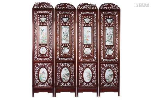 A set of four carved wooden panels, each set with four polychrome porcelain plaques, decorated