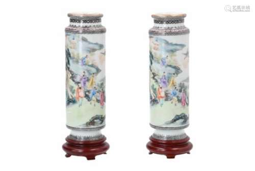 A pair of polychrome porcelain vases on wooden base, decorated with figures in a mountainous