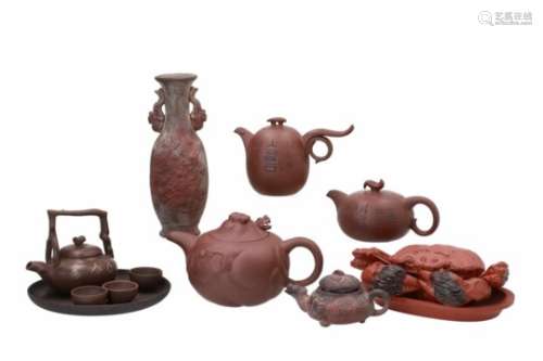 Lot of Yixing items, including four teapots, one vase and a tea service. Marked with seal marks