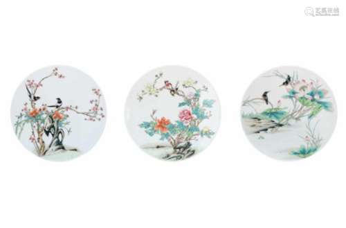 A lot of three round polychrome porcelain plaques, all decorated with flowers and birds. Unmarked.