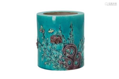 A turquoise and purple glazed porcelain brush pot, decorated in relief with a rock, flowers and