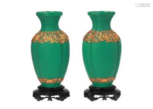 A pair of green lacquer vases on wooden base, with gilded decor of flowers. Unmarked. China, 20th