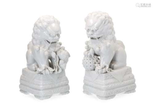 A pair of blanc de Chine sculptures of Foo dogs. One with a ball, one with a cub. Unmarked. China,