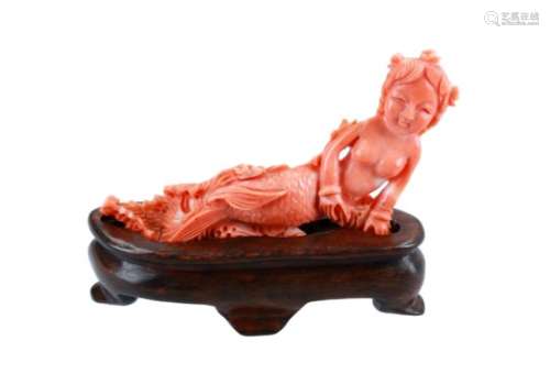 A red coral sculpture of a mermaid on wooden base. China, 20th century. L. sculpture 10 cm.