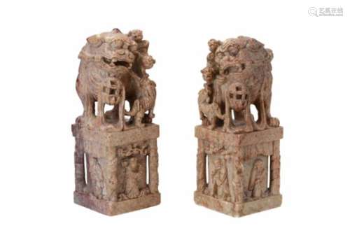 A pair of soapstone stamps, decorated with figures and lions. China, 19th century. H. 21 cm.