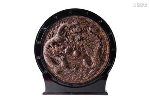 A round plaque made of pressed black tea in wooden frame, decorated with a phoenix and a five-clawed