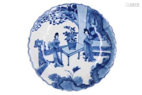 A blue and white porcelain deep saucer with scalloped rim, decorated with long Elizas. Marked with