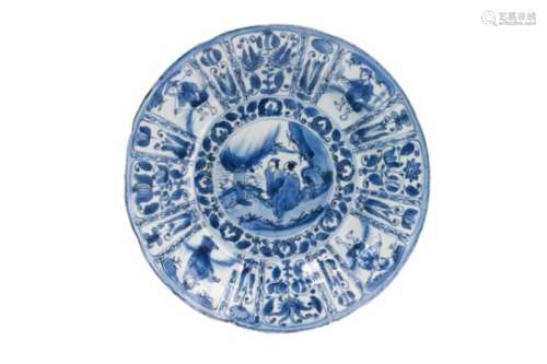 A blue and white porcelain deep charger, decorated with figures in a garden. The rim with reserves