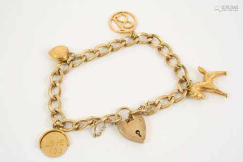 A GOLD CHARM BRACELET with padlock clasp and suspending four 9ct. gold charms, total weight 18.4