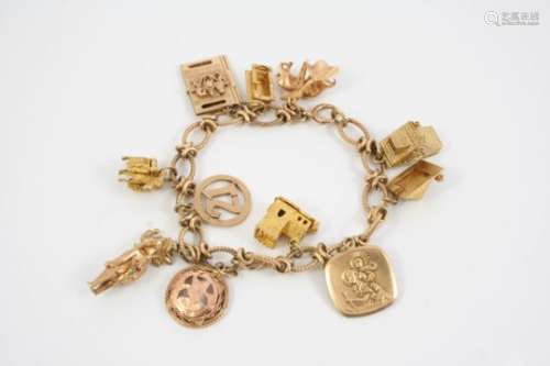 A 9CT. GOLD OVAL LINK BRACELET suspending assorted 9ct. gold charms, total weight 54 grams.