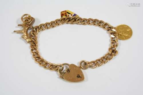 A 9CT. GOLD CURB LINK BRACELET with padlock clasp and suspending three 9ct. gold charms, total