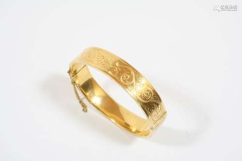 AN 18CT. GOLD HALF HINGED BANGLE with scrolling foliate decoration to one side, 27.6 grams.