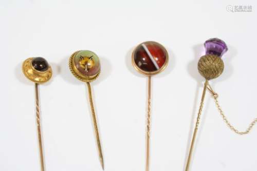 A REVERSE CARVED CRYSTAL INTAGLIO STICK PIN depicting a fox's head, together with a garnet and