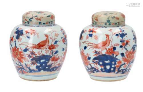 A pair of Imari porcelain ginger jars with wooden lids, decorated with flowers and birds.