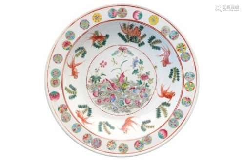 A polychrome porcelain deep charger, decorated with orchids and fish. The rim with reserves