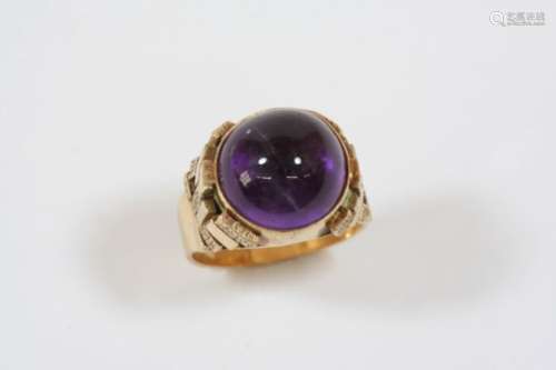 AN AMETHYST SINGLE STONE RING the circular cabochon amethyst is set in gold, with ornate geometric