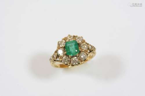 AN EMERALD AND DIAMOND CLUSTER RING the octagonal-shaped emerald is set within a surround of eight