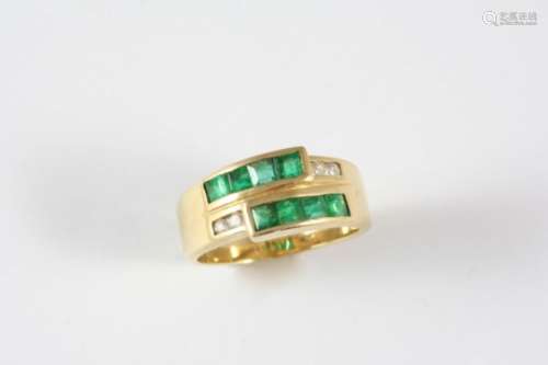 AN EMERALD AND DIAMOND RING the gold band is mounted with eight calibre-cut emeralds and four