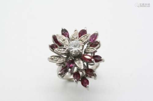 A RUBY AND DIAMOND CLUSTER RING the flowerhead design is centred with a circular-cut diamond, with