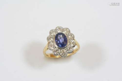 A SAPPHIRE AND DIAMOND CLUSTER RING the oval-shaped sapphire is set within a surround of ten