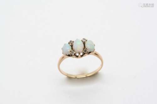 AN OPAL AND DIAMOND RING the three slightly graduated oval-shaped solid white opals are set with