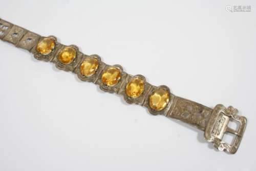A CITRINE AND SILVER BRACELET the foliate engraved belt design is mounted with six oval-shaped