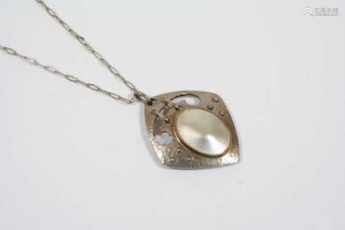 A MOTHER OF PEARL AND SILVER PENDANT BY MURRLE BENNETT & CO. the openwork hammered silver mount is