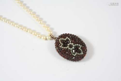 AN EARLY 20TH CENTURY GARNET AND PEARL LOCKET PENDANT the gold double sided locket is set with
