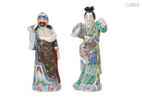 A pair of polychrome porcelain sculptures, depicting a man and lady. Marked with characters.