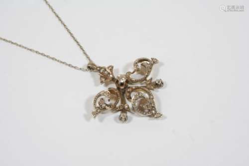 A VICTORIAN DIAMOND PENDANT the openwork scrolling design is set overall with circular and rose-