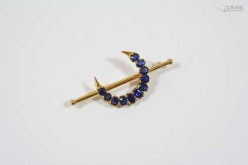 A SAPPHIRE CLOSED CRESCENT BROOCH formed with graduated oval-shaped sapphires, in gold, 5.4cm.
