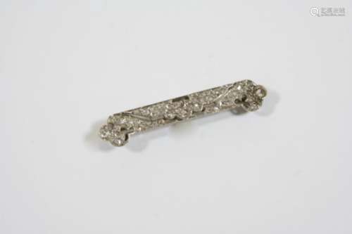 AN EARLY 20TH CENTURY DIAMOND BROOCH of scrolling openwork form and set overall with graduated