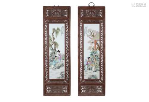 A pair of two polychrome porcelain plaques in wooden frame, depicting figures, flowers and