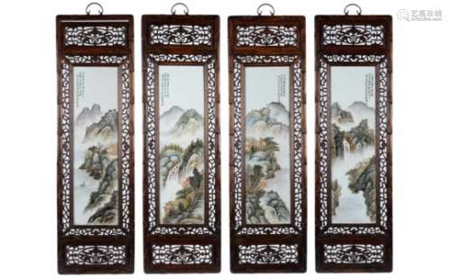 A set of four polychrome porcelain plaques in wooden frames, decorated with a mountainous