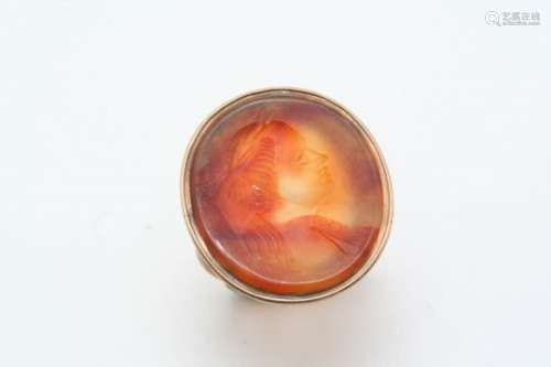 A CARNELIAN CARVED INTAGLIO RING depicting the head and shoulders of a mythological figure, in