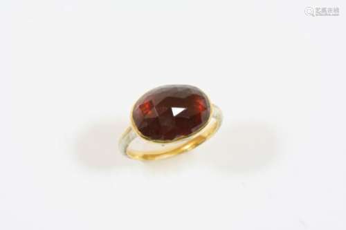 A GEORGIAN GARNET AND ENAMEL RING the oval shaped faceted foil backed garnet is set in a gold