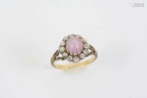 A STAR SAPPHIRE AND DIAMOND CLUSTER RING the oval-shaped star sapphire is set within a surround of