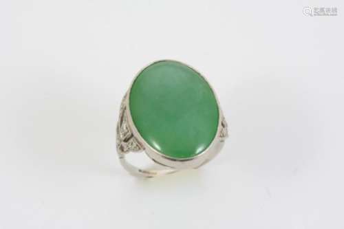 AN ART DECO JADE AND DIAMOND RING the oval section of jade is mounted with single-cut diamonds to