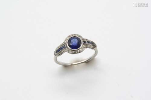 AN EARLY 20TH CENTURY SAPPHIRE AND DIAMOND CLUSTER RING the oval-shaped sapphire is set within a