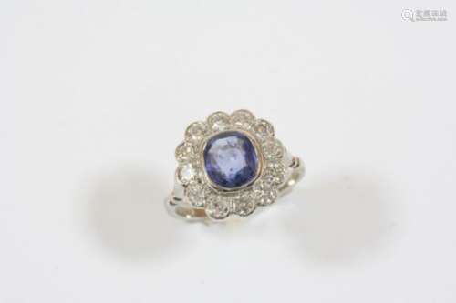A SAPPHIRE AND DIAMOND CLUSTER RING the oval-shaped sapphire is set within a surround of twelve
