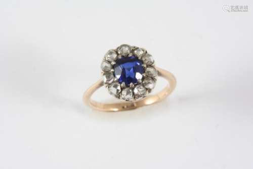 A DIAMOND AND SYNTHETIC SAPPHIRE CLUSTER RING the circular synthetic sapphire is set within a